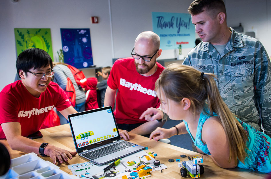 Raytheon volunteers working with Military Club kid