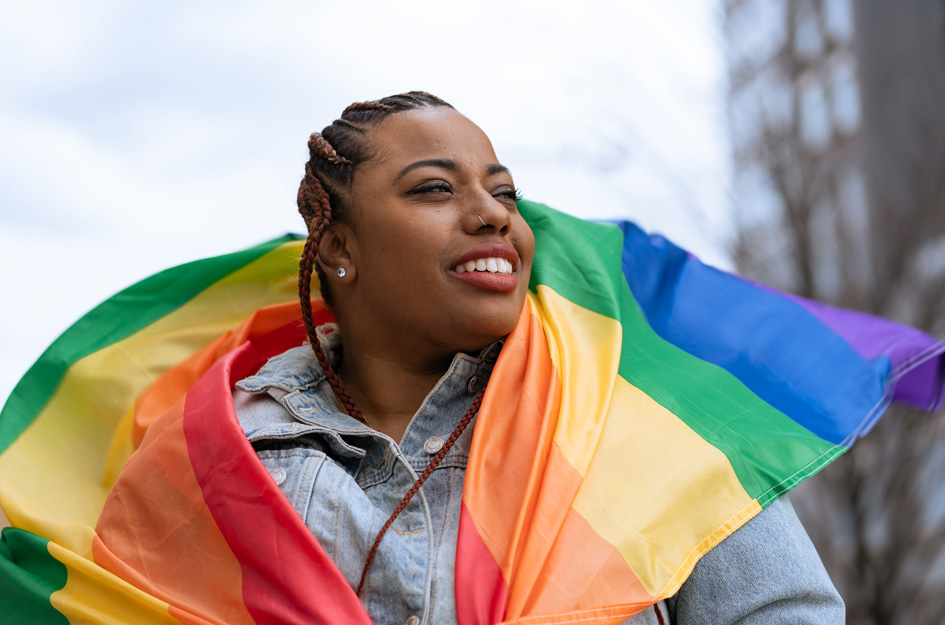 Teen girl wrapped in rainbow flag