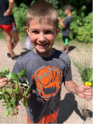 Boys & Girls Club of Bay Mills youth harvesting fruits and vegetables from Club garden