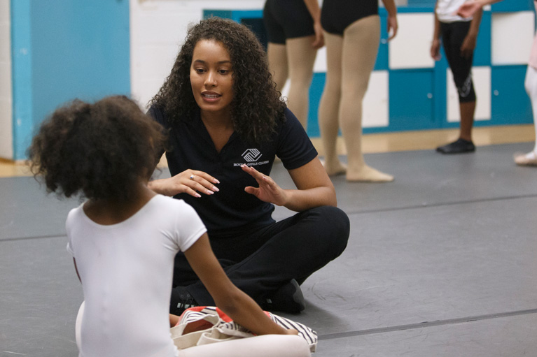 Youth Development Professional sitting on floor talking to Club kid