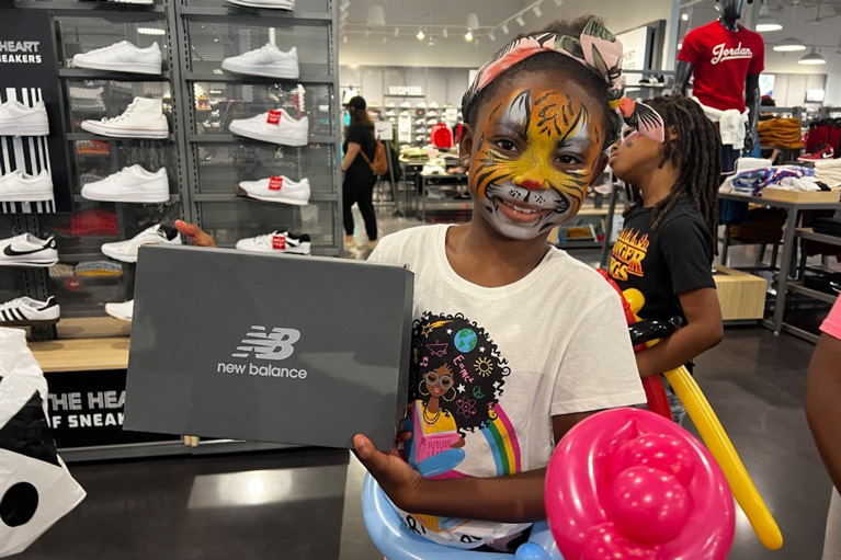 Club kid in store with big smile and shoe box