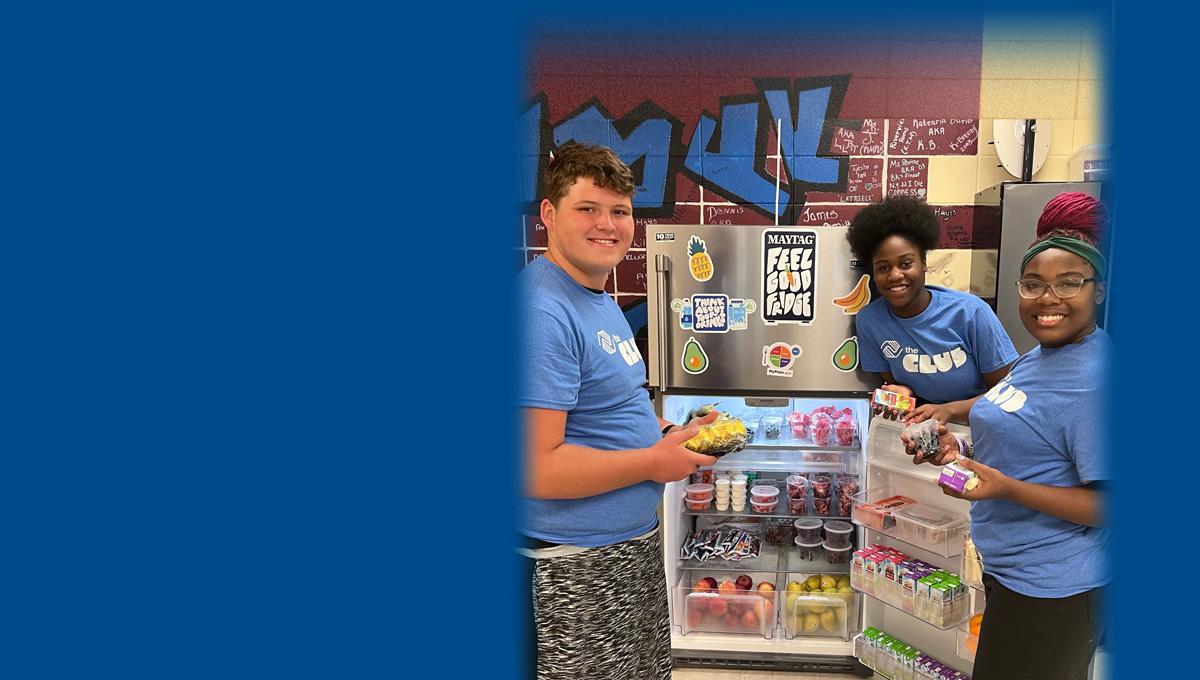 Maytag hero with 2 Club teens smiling in front of Feel Good Fridge