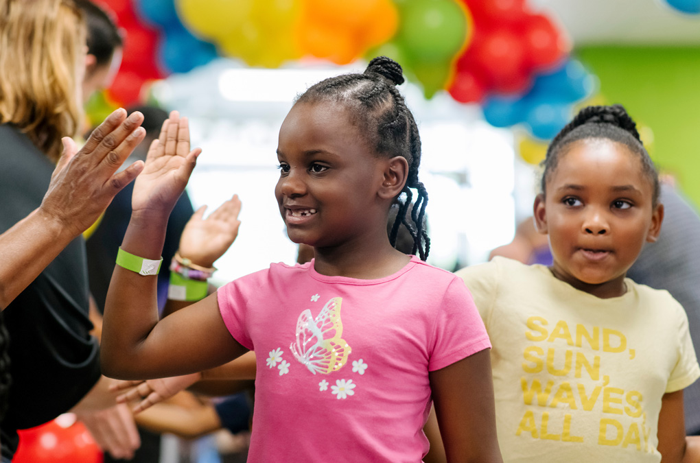 Cute Club kids high-fiving and smiling