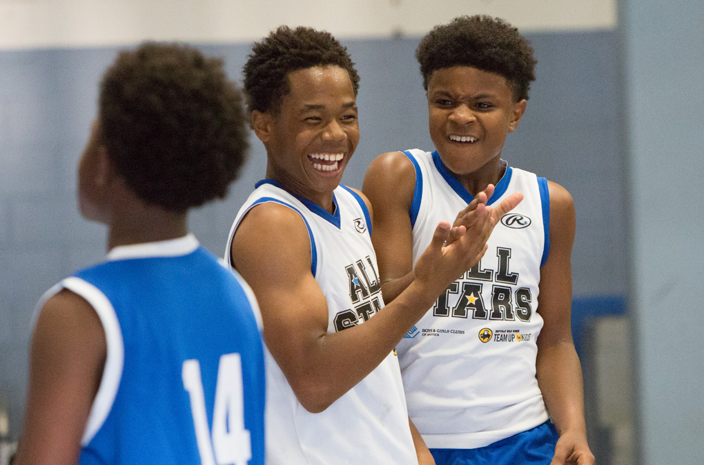 Three Club kids playing basketball and laughing