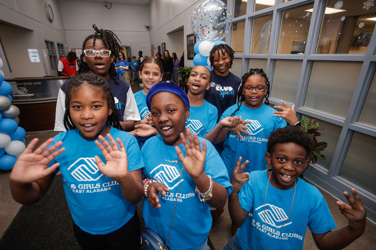 Boys & Girls Clubs of East Alabama Club kids smiling and waving at camera