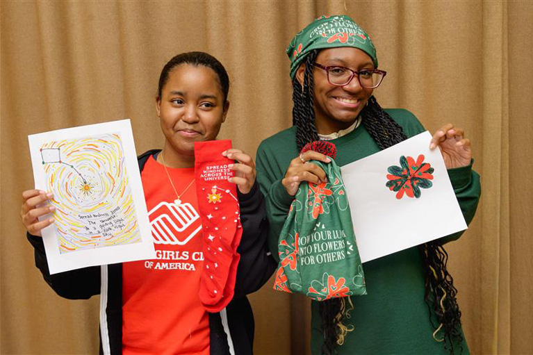 2 East Harlem teens spread kindness by debuting original designs at Coca-Cola’s Holiday Caravan.