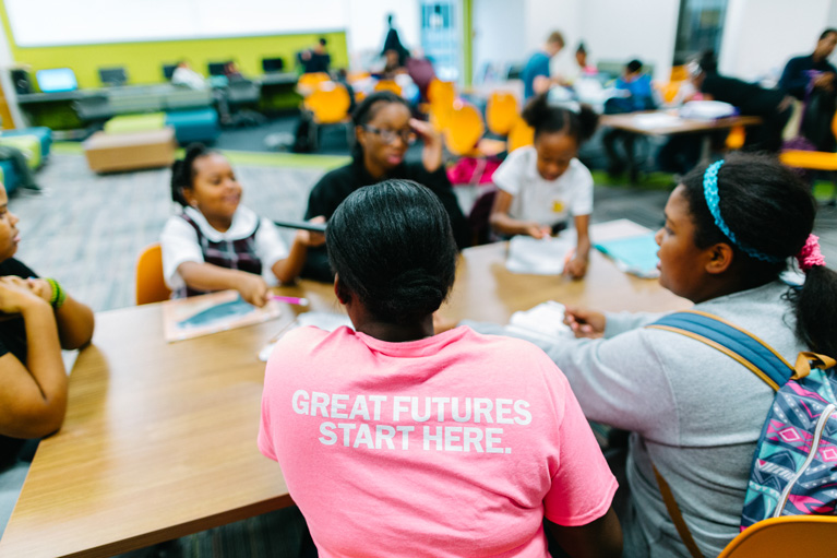 Club kids at a table working on a project