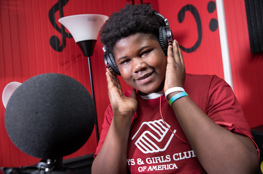 Black teen boy in recording studio smiling at the camera