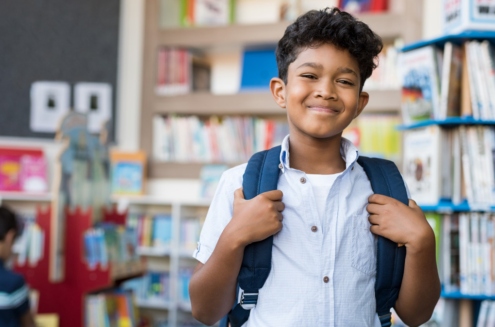 Club kid smiling at camera with backpack on